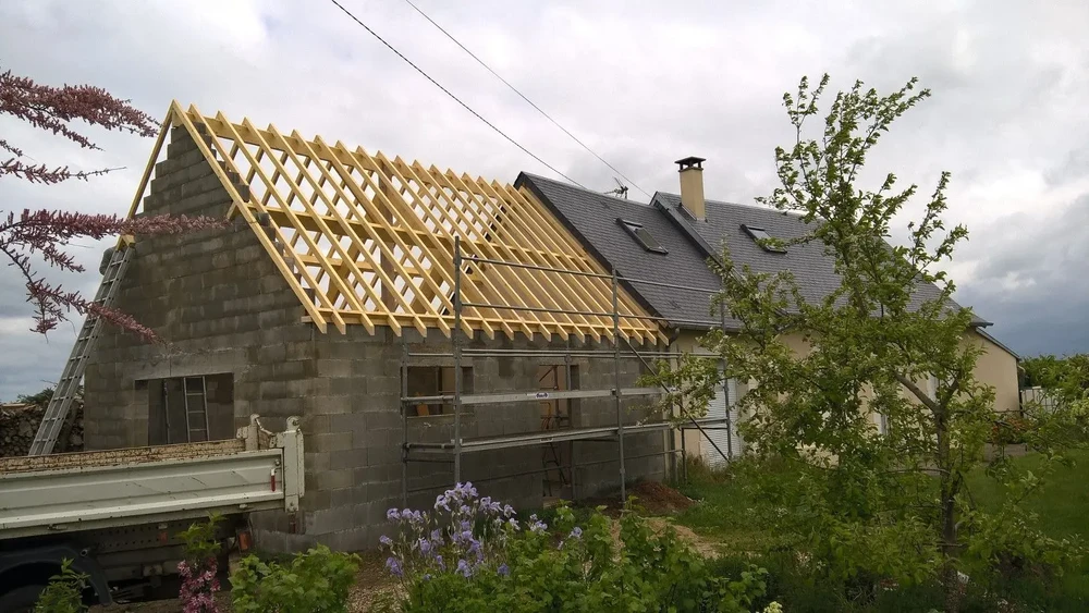Chantier de construction résidentielle en cours avec extension d'une maison existante