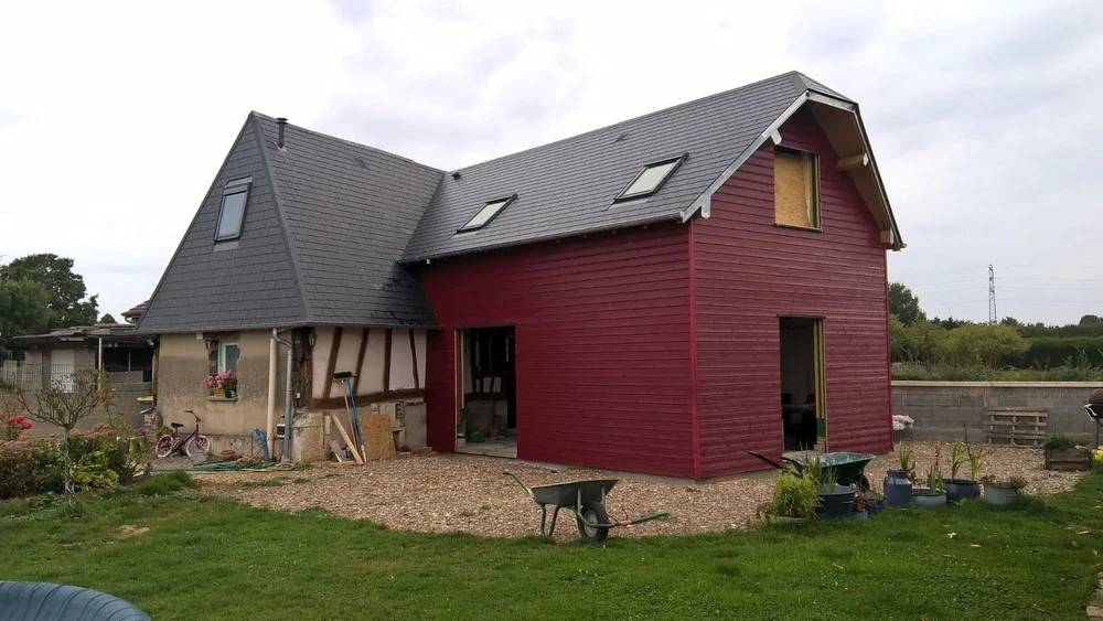 Chantier de construction résidentielle en cours avec maison à extension moderne