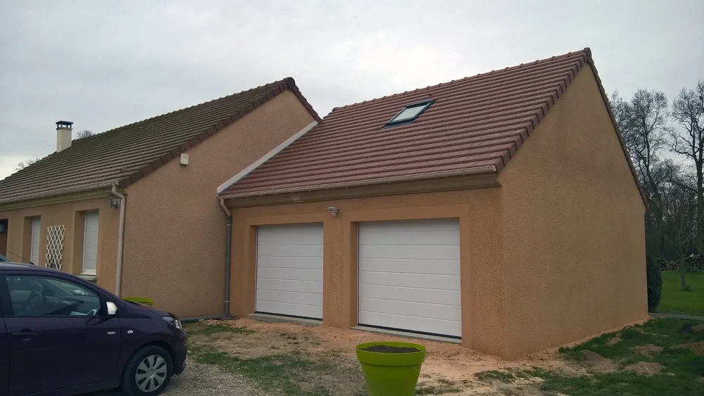 Combles aménagés sous charpente traditionnelle en bois avec poutres apparentes peintes en blanc