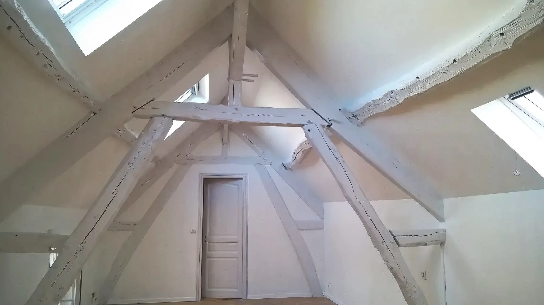 Chantier de r&eacute;novation d'appartement en cours avec ouvrier travaillant sur finitions